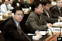 资料照：2001年12月19日星期三，中国首席贸易谈判代表龙永图（最左边）出席在瑞士日内瓦举行的世界贸易组织总理事会会议。中国作为世界贸易组织的新成员首次参加了这次会议。