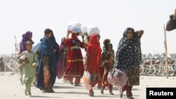 People from Afghanistan with their belongings cross into Pakistan at the 'Friendship Gate' crossing point, in the Pakistan-Afghanistan border town of Chaman, Pakistan, Sep. 7, 2021. 