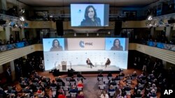 U.S. Vice President Kamala Harris, right on stage, speaks during the Munich Security Conference, as conference chairman Wolfgang Ischinger, left on stage, looks on, in Munich, Germany, Feb. 19, 2022.