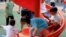 FILE - Children at a playground inside a shopping complex in Shanghai, China, June 1, 2021.