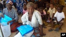 FILE - Women hold mosquito nets after receiving them at a distribution point in Sesheke, Zambia, Sept. 30, 2010.
