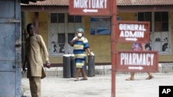 Des gens entrent dans l'enceinte de l'hôpital de Yaba Mainland où est traité un Italien atteint du coronavirus. L'homme venu du Milan pour un voyage d'affaires est le premier cas du virus COVID-19 au Nigeria.(Photo: AP 28 février 2020. )