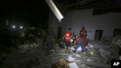 Petugas Bulan Sabit Merah mengevakuasi jenazah para migran setelah serangan udara terhadap sebuah pusat penahanan di Tajoura, timur Tripoli, ibu kota Libya, 3 Juli 2019.
