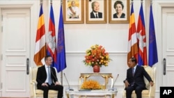 Hungarian Foreign Minister Peter Szijjarto, left, talks with Cambodian Prime Minister Hun Sen during a meeting at Peace Palace in Phnom Penh, Cambodia, Tuesday, Nov. 3, 2020. (Pool Photo via AP)