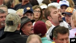 FILE - A protester who disrupted a rally for Republican presidential candidate Donald Trump is removed from the arena, March 1, 2016, in Louisville, Ky.