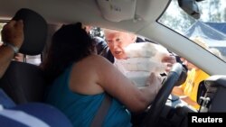 U.S. President Donald Trump hands out food while visiting a distribution center outside the Temple Baptist Church while on a tour of Hurricane Florence recovery efforts in New Bern, North Carolina, U.S., Sept. 19, 2018. 