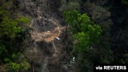 The bodies of members of the demobilized Revolutionary Armed Forces of Colombia (FARC) are covered by sheets in this handout photo provided by the Colombian Ministry of Defense, Feb. 24, 2022.