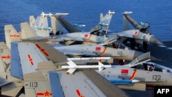 资料照 - 图片显示2018年4月在一次海上演练中，中国海军第一艘航母“辽宁号”甲板上停满了中国的歼-15战机。