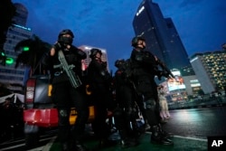 Petugas kepolisian berjaga di area bisnis utama di Jakarta, menjelang malam pergantian tahun, 31 Desember 2023. (Foto: Achmad Ibrahim/AFP)