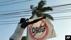 A former addict straightens a flag outside a sober house in Zanzibar, an island ravaged by heroin imported from Asia, February 9, 2012.