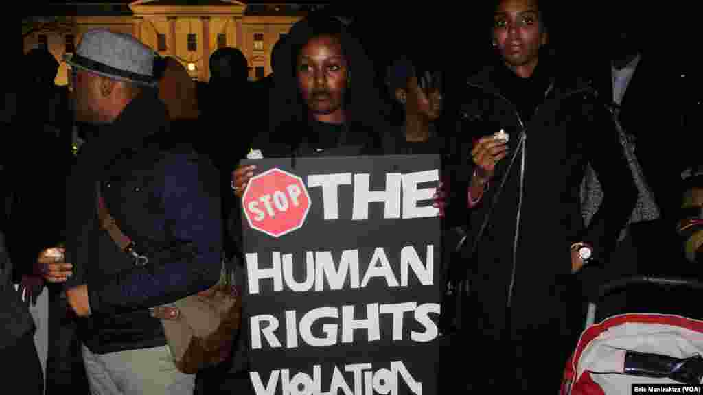 Une dame brandit un calicot avec mention "arretez les violations des droits de l'homme" durant le recueillement devant la Maison Blanche en mémoire des victimes de la tuerie dans certains quartiers de Bujumbura le weekend dernier, 17 décembre 2015. VOA/Er