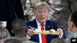 President Donald Trump holds up a tray of Thanksgiving dinner during a surprise Thanksgiving Day visit to the troops,Nov. 28, 2019, at Bagram Air Field, Afghanistan.