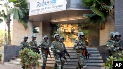 Des soldats de la garde présidentielle patrouillent devant l'hôtel Radisson Blu à Bamako, au Mali, le 21 novembre 2015.