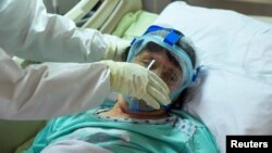 ARHIVA - Zdravstveni radnik brine se o oboleloj od Kovida 19, u Opštoj bolnici u Novom Pazaru, 15. marta 2021. (Foto: Rojters/Zorana Jevtić)