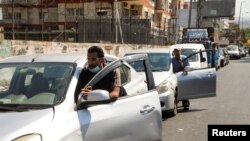 People push their cars due to a lack of fuel, near a gas station in Dora, Lebanon, Aug. 17, 2021. 