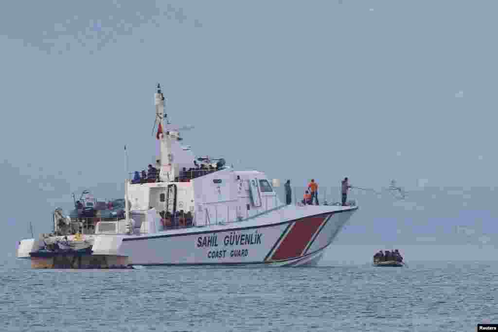 A line is thrown from a Turkish Coast Guard ship off the shores of Bodrum, Turkey, as migrants in a dinghy paddle on Mediterrean Sea in a failed attempt of crossing to the Greek island of Kos.