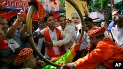 Supporters of India’s ruling Bharatiya Janata Party (BJP) celebrate as early results indicated the party leading in the Maharashtra state Assembly elections in Mumbai, India, Oct. 19, 2014. 
