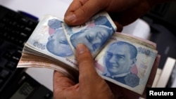 A money changer counts Turkish lira notes at a currency exchange office in Istanbul, Aug. 2, 2018. 
