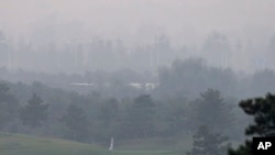Seorang pemain golf terpaksa mengikuti pertandingan yang diselenggarakan di lapangan golf 'Pine Valley' di pinggiran kota Beijing, China dalam kabut tebal akibat polusi yang menyelimuti wilayah tersebut (6/10). 