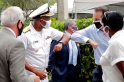 Surgeon General Dr. Jerome Adams, left, bumps elbows at Sergio's Restaurant in Doral, Florida, July 23, 2020.