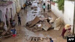 Des personnes dans une rue inondée par les pluies torrentielles dans la ville de Mhamdia, près de Tunis, la capitale tunisienne, le 18 octobre 2018.