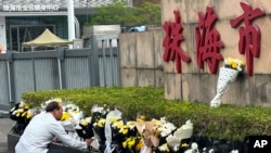 人们在珠海体育中心外摆放花束悼念遭恶意开车冲撞的受害者，但外媒目击悼念物品随后被官方人员移除。(美联社：2024年11月13日)