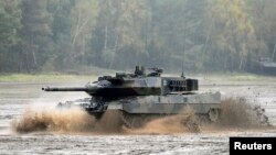 FILE - A Leopard 2 tank crosses a river during a German army, the Bundeswehr, training and information day in Munster, Germany, October 9, 2015.