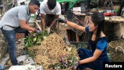 FILE - Inda Aung Soe (L) and his wife Aye Aye Than collect food waste at the wet market to produce organic fertilizer in Yangon, Myanmar, June 3, 2020. (REUTERS/Zaw Naing Oo)
