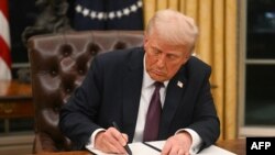 Picha ya maktaba ya Trump akitia saini amri ya kiutendaji. January 20, 2025. (Photo by Jim WATSON / POOL / AFP)