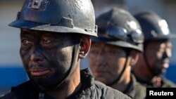 FILE - Miners wait in lines to shower during a break near a coal mine in Heshun county, Shanxi province.