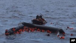 FILE - Refugees and migrants are rescued by members of the Spanish NGO Proactiva Open Arms, after leaving Libya trying to reach European soil aboard an overcrowded rubber boat in the Mediterranean sea, Nov. 11, 2020.