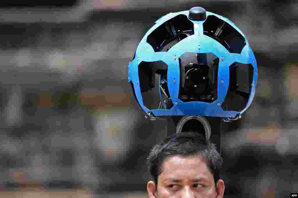 A Cambodian technician carries a back-pack mounted with a device housing 15 cameras as he demonstrates the technique used to digitally map the Angkor Wat temple in north-western Cambodia. Angkor Wat has been digitally mapped for the first time, allowing people to visit the famed temples from the comfort of their armchairs using Google Street View.