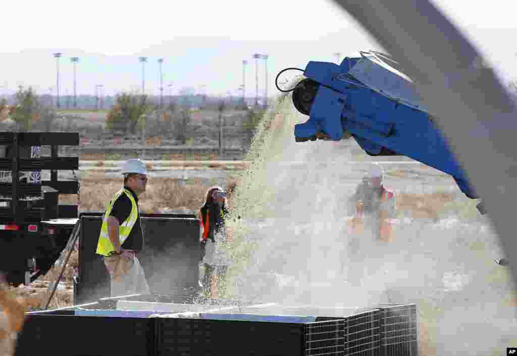 A U.S. Fish and Wildlife Service employee keeps watch as pulverized confiscated ivory emerges from a rock crusher after being destroyed during an event at the National Wildlife Property Repository, Commerce City, Colo., Nov. 14, 2013. 