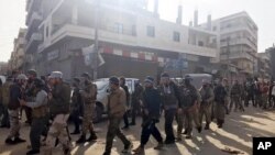 រូបឯកសារ៖ ក្រុម​ទាហានរំដោះស៊ីរីឬ Free Syrian Army គាំទ្រ​ដោយ​តួកគី ដើរ​នៅ​ក្នុង​ស្រុក Afrin ភាគពាយ័ព្យ​ប្រទេសស៊ីរី កាលពីថ្ងៃទី១៨ ខែមីនា ឆ្នាំ២០១៨។ (រូបភាព AP)