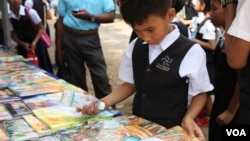 អ្នក​ចូល​រួម​ម្នាក់ កំពុង​អាន​សៀវភៅ​នៅ​ស្តង់​សៀវភៅ​មួយ​ក្នុង​«​ពិព័រណ៌​សៀវភៅ​នៅ​កម្ពុជា​ លើកទី៤​» នៅឯ​បណ្ណាល័យ​ជាតិ​ ​នៅ​ថ្ងៃ​ទី​១១​ ខែ​ធ្នូ​ ឆ្នាំ​២០១៥។ (ហ៊ាន សុជាតា/ VOA)​ 