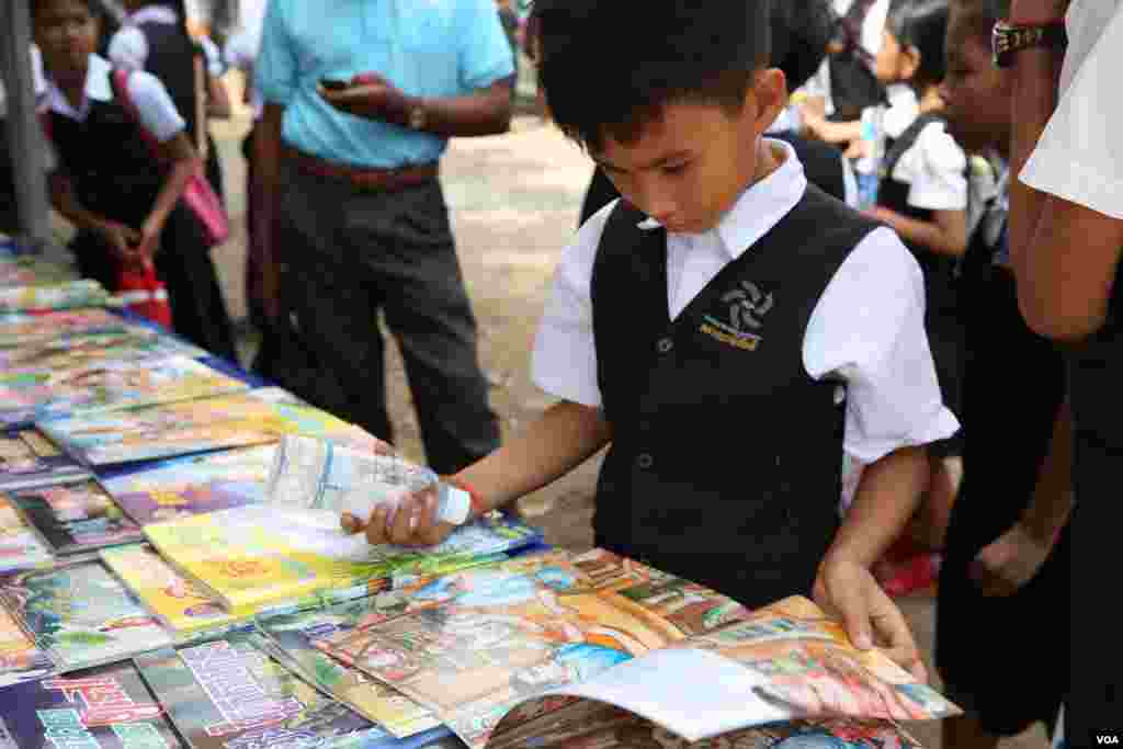 អ្នក​ចូល​រួម​ម្នាក់ កំពុង​អាន​សៀវភៅ​នៅ​ស្តង់​សៀវភៅ​មួយ​ក្នុង​&laquo;​ពិព័រណ៌​សៀវភៅ​នៅ​កម្ពុជា​ លើកទី៤​&raquo; នៅឯ​បណ្ណាល័យ​ជាតិ​ ​នៅ​ថ្ងៃ​ទី​១១​ ខែ​ធ្នូ​ ឆ្នាំ​២០១៥។ (ហ៊ាន សុជាតា/ VOA)