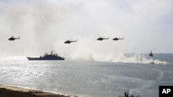 FILE - Russian navy ships and helicopters take a part in a landing operation during military drills at Crimea's Black Sea coast, Sept. 9, 2016.