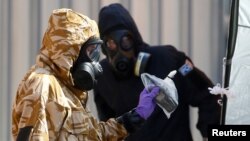  Forensic investigators, wearing protective suits, emerge from the rear of John Baker House, after it was confirmed that two people had been poisoned with the nerve-agent Novichok, in Amesbury, Britain, July 6, 2018. 