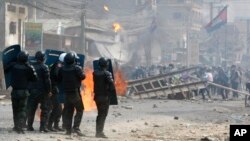 FILE: Cambodian riot police prepare to confront with garment workers throwing stones and bricks near a factory on the Stung Meanchey complex on the outskirts of Phnom Penh, Cambodia, Friday, Jan. 3, 2014. 