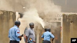 Cảnh sát bắn lựu đạn cay và rượt đuổi những thanh niên Hồi giáo trong lúc những kẻ gây rối nổi lửa đốt vỏ xe và một nhà thờ ở Mombasa, Kenya (4/10/2013). 