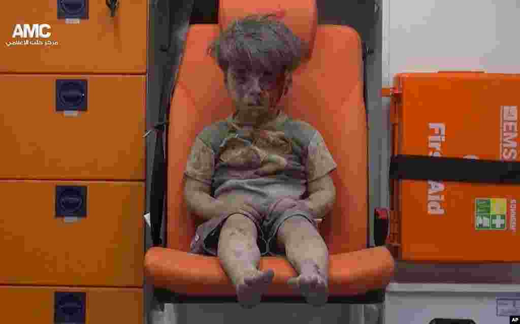 In this frame grab taken from video provided by the Syrian anti-government activist group Aleppo Media Center (AMC), a child sits in an ambulance after being pulled out of a building hit by an airstirke, in Aleppo, Aug. 17, 2016.