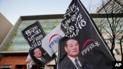 Mourners gather outside a funeral hall of the late former South Korean President Chun Doo-hwan in Seoul, South Korea, Nov. 27, 2021. The flags read: 'President Chun Doo-hwan rests in peace.' 