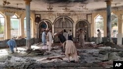 People view the damage inside of a mosque following a bombing in the provincial capital of Kunduz, northern Afghanistan, Oct. 8, 2021.