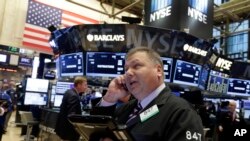 U.S. stock prices fell sharply on Monday. This photo shows a trader on the floor of the New York Stock Exchange. (AP Photo/Richard Drew) 