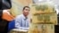 FILE - Stacks of 100,000 Vietnamese Dong notes are pictured as employees count money at a branch of the Bank for Investment and Development of Vietnam (BIDV) in Hanoi. 