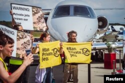 Activists hold banners during a demonstration against Private jets at the European Business Aviation Convention & Exhibition (EBACE) in Geneva, Switzerland, May 23, 2023. Thomas Wolf/Stay Grounded/Handout via REUTERS