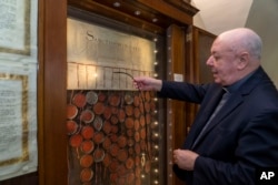 Bishop Sergio Pagano shows the original 1530 letter kept in his office at The Vatican, Feb. 14, 2024, that attempted to pressure Pope Clement VII into granting the divorce to King Henry VIII from his wife Catherine of Aragon that was denied. (AP Photo/Domenico Stinellis)