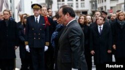 Presiden Perancis Francois Hollande (tengah) dan Walikota Paris Anne Hidalgo menghadiri acara pembukaan tabir prasasti untuk menghormati korban serangan pada bulan Januari tahun lalu di luar bekas kantor koran satir mingguan Perancis Charlie Hebdo.