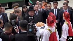 Pemimpin Korea Utara, Kim Jong-un (tengah) disambut oleh gadis-gadis berpakaian tradisional Rusia setibanya di stasiun kereta Khasan di wilayah Primorye, Rusia, Rabu, 24 April 2019.