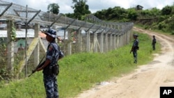 档案照 - 2018年6月29日，缅甸边防人员在缅甸与孟加拉国之间的无人区附近站岗提供安全保障，地点位于若开邦北部貌昂道陶漂拉提亚村附近。